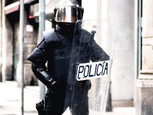 Französische Polizeibeamte verwenden Schutzschild zur Bekämpfung von Ausschreitungen.
